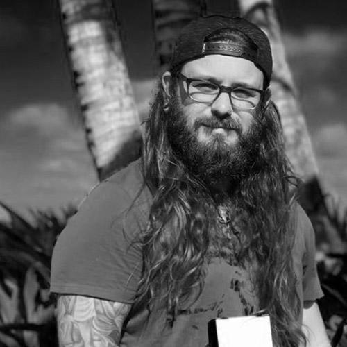 Tattoo artist with long hair and glasses outdoors, promoting FYT Tattoo Supplies New York