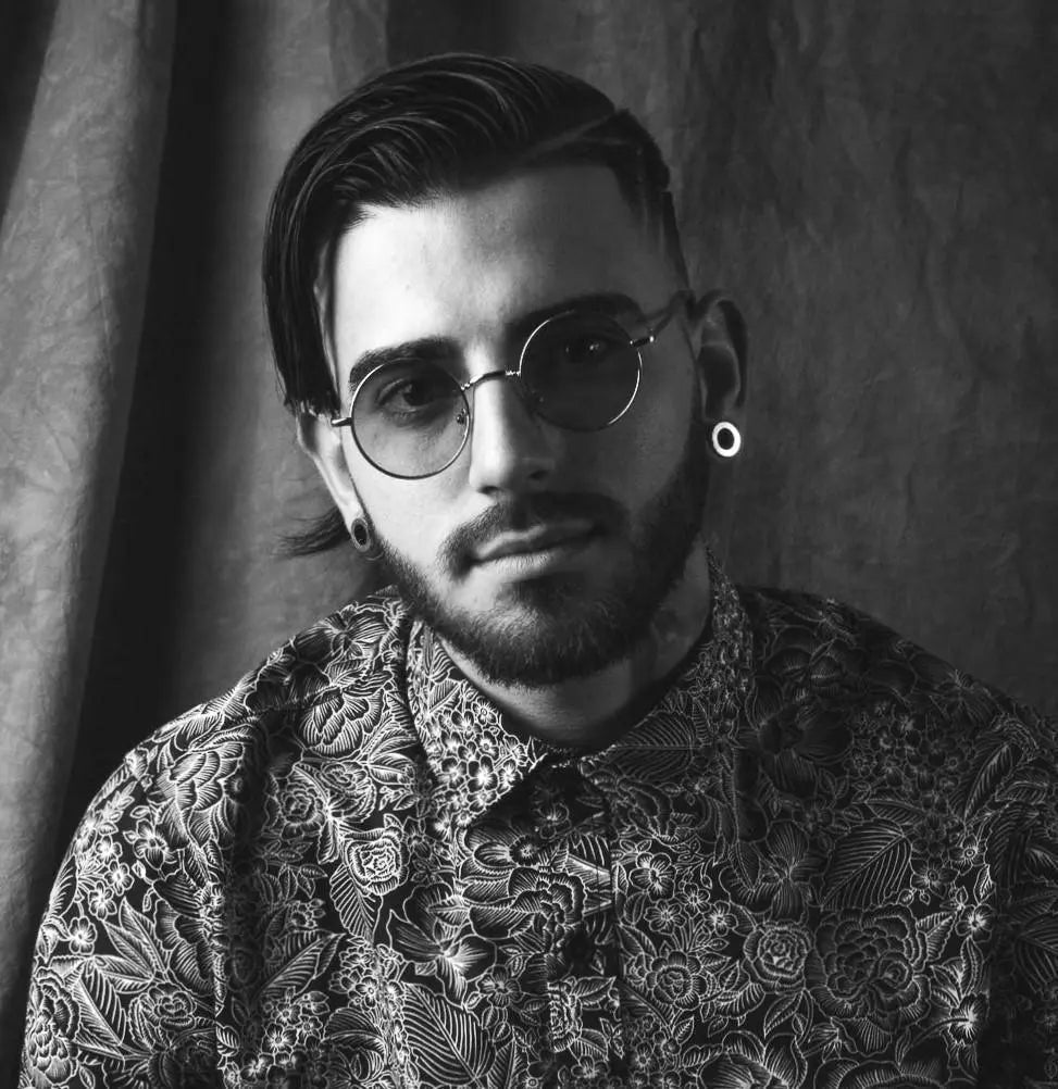 Tattoo artist in floral shirt and round glasses, FYT Tattoo Supplies New York