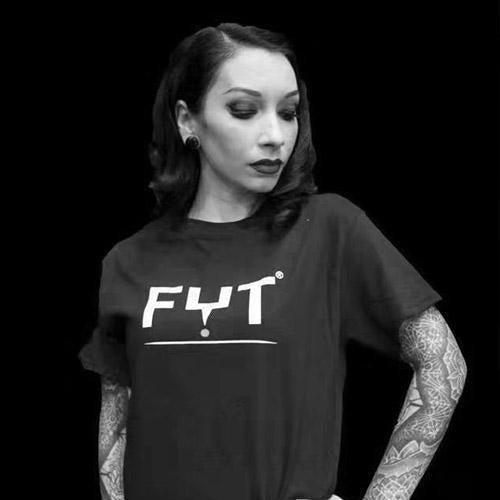 Tattooed woman wearing FYT Tattoo Supplies shirt, black background, New York branding