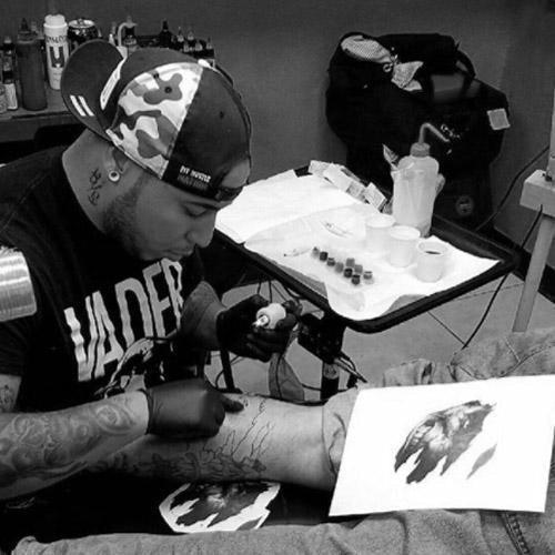 Tattoo artist using FYT tattoo supplies and cartridges on a client's leg in New York studio