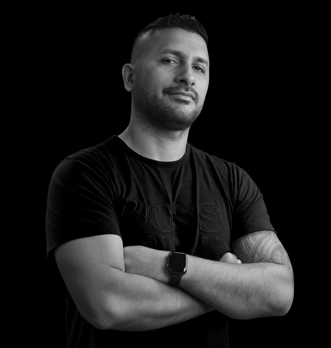 Tattoo artist in black shirt with arm tattoos, FYT Tattoo Supplies New York background.