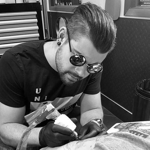 Tattoo artist using FYT tattoo supplies and cartridges in a professional New York studio.