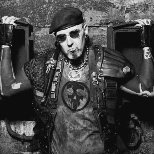 Tattooed man in punk outfit with accessories, posing in urban setting, FYT Tattoo Supplies New York